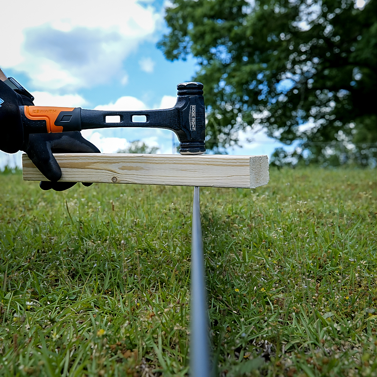 Installing CorTen landscape edging with Edge Right Installation Kit hammer and wood blocks.