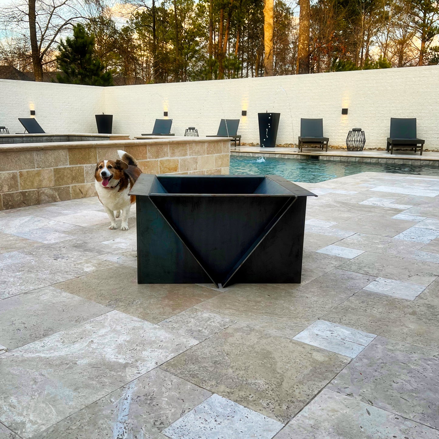 Edge Right's "campfire" Fire Pit placed on patio with pool in the background.