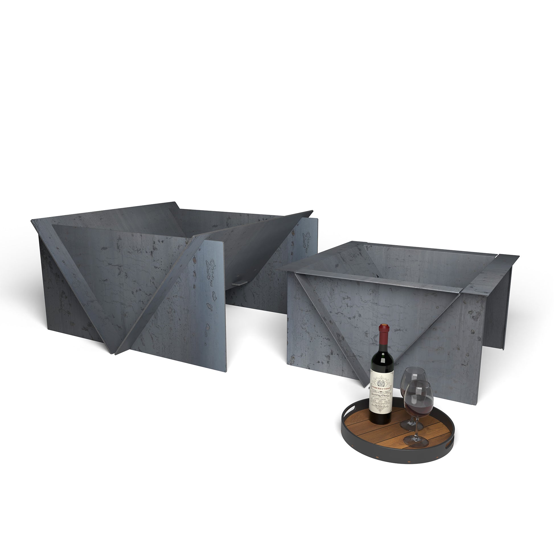 Modern steel fire pit set with precision built design, displayed with a bottle and glasses on a tray in front.