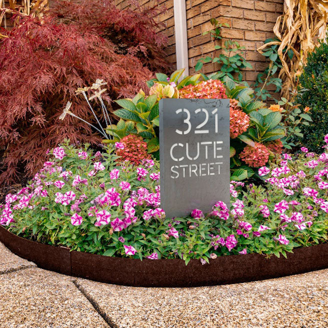 Edge Right's Address Sign inside of a flower bed that is enclosed with Edge Right's Corten Steel metal edging that has developed a protective patina. 