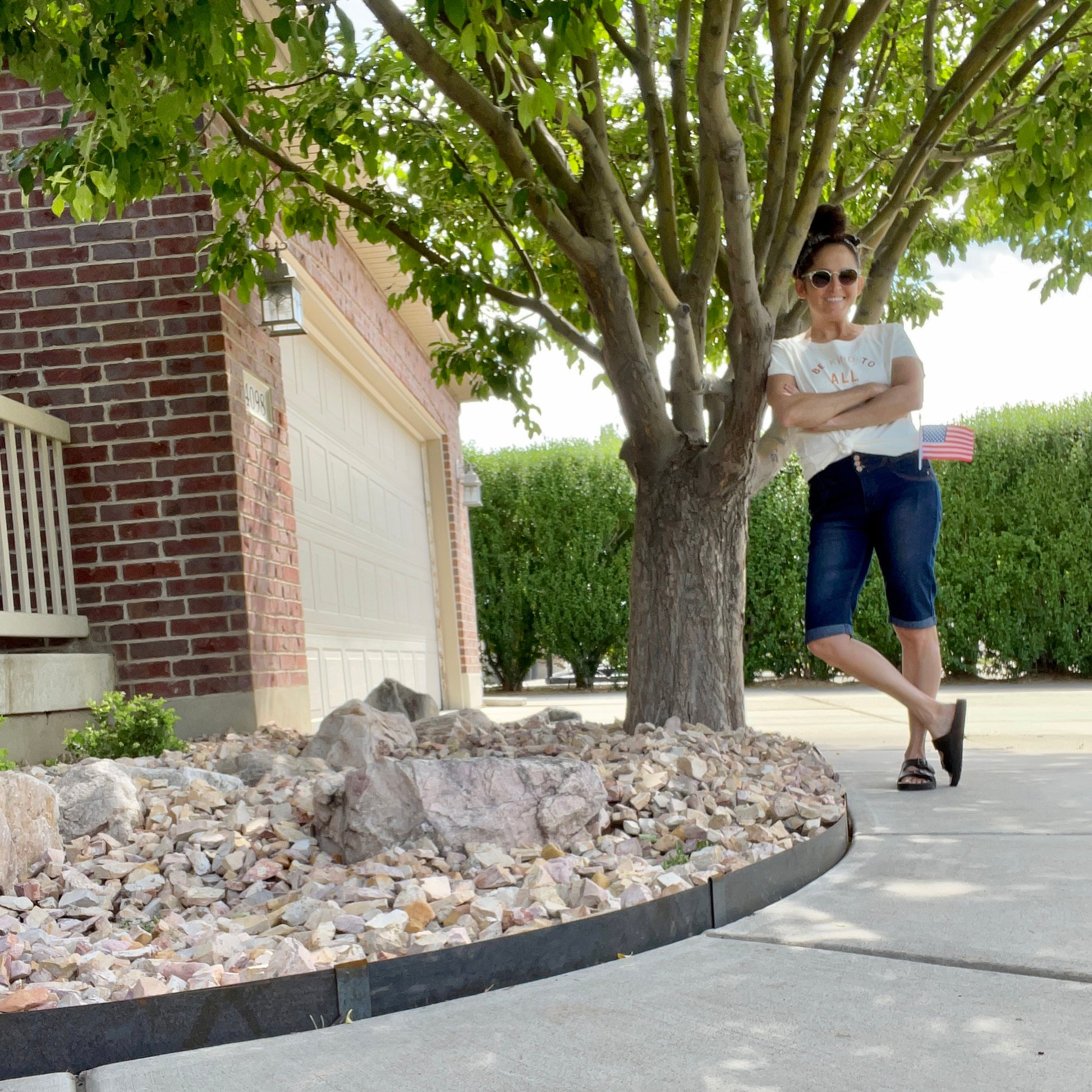 Image of Corten steel metal landscape edging installed in a semi-circle to edge a sidewalk. Enclosed in the semi-circle, the edging keeps landscape rocks in place for a clean, finished look. 